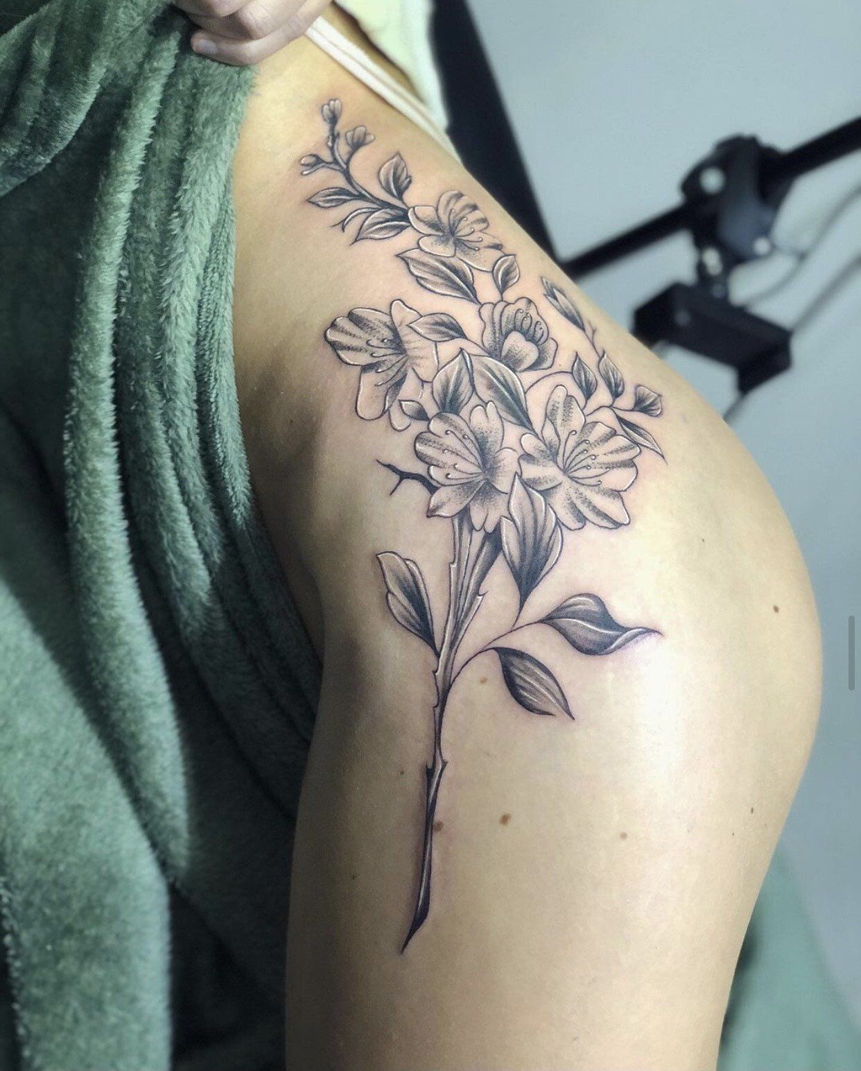 A woman has a tattoo of flowers on her shoulder