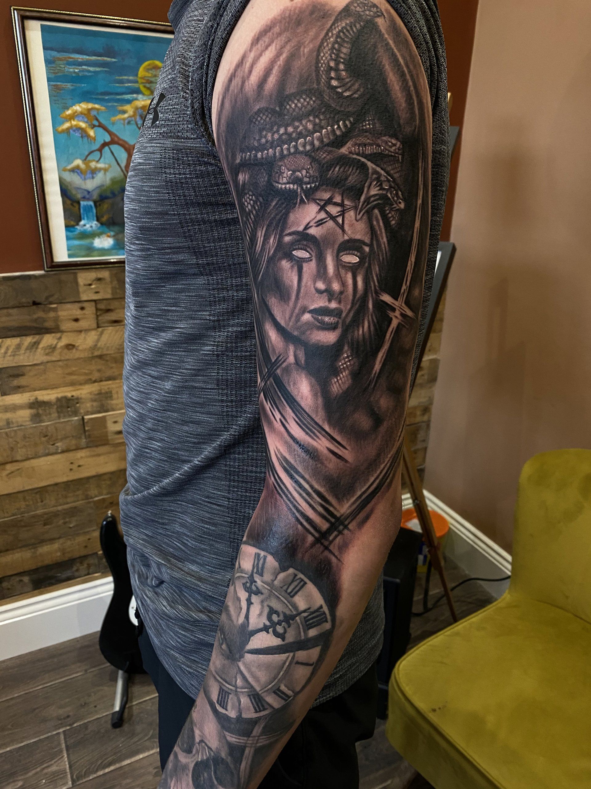 A man has a tattoo of a woman 's face on his arm.
